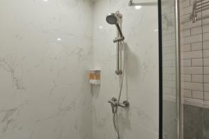 a shower in a bathroom with a glass door at Grand BS Airport Hotel Suvarnabhumi in Lat Krabang