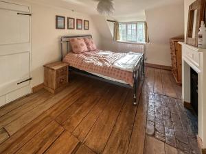 um quarto com uma cama e piso em madeira em Bakers Retreat em Cottesmore