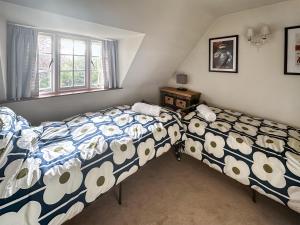 a bedroom with two beds and a window at Bakers Retreat in Cottesmore