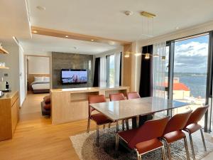 a dining room and living room with a table and chairs at Hotel Fine Jeju in Seogwipo