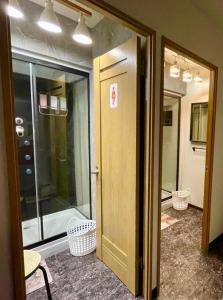 una puerta abierta a una habitación con una puerta de cristal en 民泊Murakami International, en Kishiwada