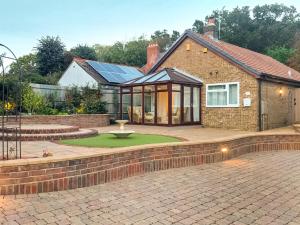 a house with a courtyard with a fountain in front of it at Kennet Valley View in Tilehurst