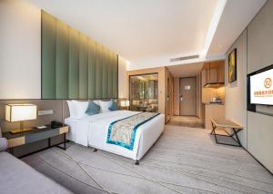 una camera d'albergo con un grande letto e una TV di Qin Huang Yong An Boutique Hotel a Chengdu