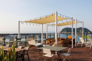a patio with tables and chairs on a deck at Hotel Fine Jeju in Seogwipo