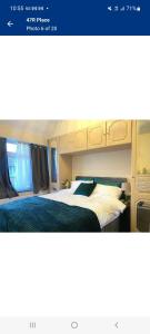 um quarto com uma cama com um cobertor azul em 47R Place em Dagenham