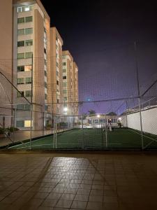 un campo da tennis di fronte ad alcuni edifici di notte di Apartamento completo a Ibagué