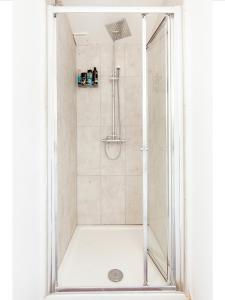 a shower with a glass door in a bathroom at Beechtree House in Cheshunt
