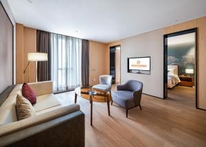 ein Hotelzimmer mit einem Sofa, einem Stuhl und einem Bett in der Unterkunft Qin Huang Yong An Boutique Hotel in Chengdu