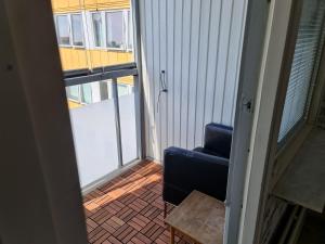 Un balcón con una silla azul y una mesa en Masthugget en Gotemburgo