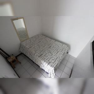 a white room with a bed and a mirror at Triplex White em Caiobá-Matinhos-Pr a 200 mt do mar in Matinhos