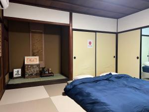 a bedroom with a blue bed and glass walls at The Pine 京都嵐山 in Kyoto