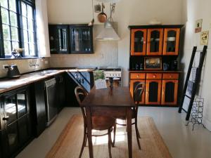 uma cozinha com uma mesa de madeira e cadeiras em Pickled Pigeon Cottage em Lawrence