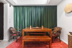 a table and chairs in a room with a green curtain at Zen State of Mind - Calming Richmond Retreat in Melbourne