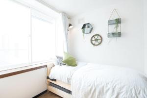 ein weißes Schlafzimmer mit einem Bett und einem Fenster in der Unterkunft SouthHouseS札幌市中心部まで徒歩5分 in Sapporo