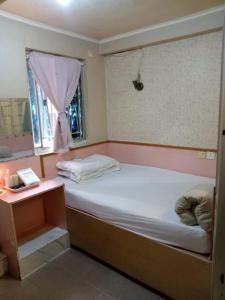 a small bedroom with a bed and a window at 嘉湖旅館 in Hong Kong