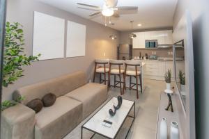 sala de estar con sofá y cocina en Exclusivo apartamento piso 23, Sky Garden, en San José