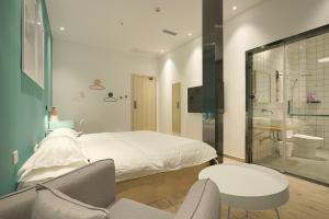 a bedroom with a bed and a bathroom with a shower at Swan's Journey International Youth Hostel - Changsha Wuyi Square IFS IFC in Changsha