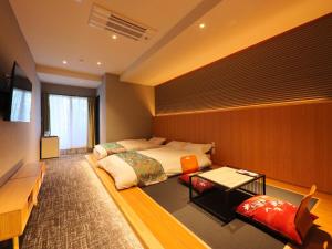 a bedroom with a bed and a table in it at Kurobe Sunvalley Hotel in Omachi