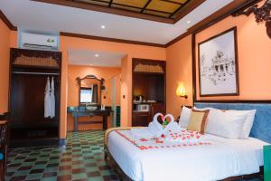 um quarto com uma grande cama branca num quarto em Spatel d'Annam - Imperial Boutique Spa & Hotel em Hue