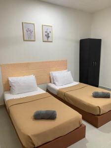 Kampong Banggol BinjaiにあるBB Durio Chaletのベッド2台が隣同士に設置された部屋です。
