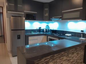 a kitchen with blue lights on the counters at Departamento acogedor en Huacachina in Ica
