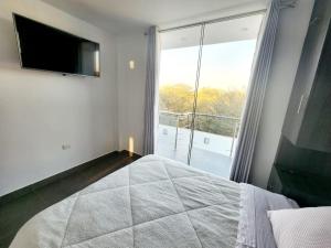 a bedroom with a large bed and a large window at Departamento acogedor en Huacachina in Ica