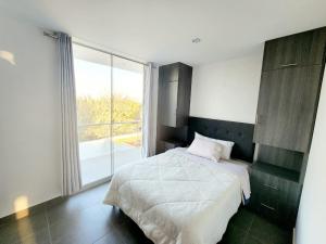 a bedroom with a bed and a large window at Departamento acogedor en Huacachina in Ica +4 photos