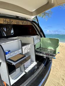 an open trunk of a car on the beach at HW Campervan Rental NO CAMPGROUND in Hauula