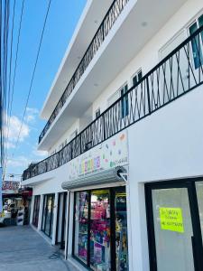 a white building with a balcony on top of it at InDomus Rooms in Bacurimi