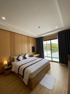 a bedroom with a large bed and a large window at Khách sạn - Nhà hàng Hoàng Phúc in Tuy Phong