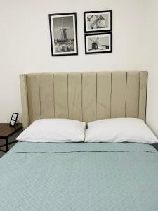 a bed with a large headboard in a bedroom at InDomus Rooms in Bacurimi