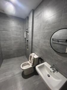 uma casa de banho com um WC, um lavatório e um espelho. em Cozy*Home @ Riverine Diamond Kuching em Kuching