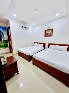 a bedroom with two beds and a table at SeaSala Beach Hotel in Vung Tau