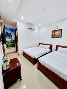 a hotel room with two beds and a table at SeaSala Beach Hotel in Vung Tau