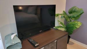 a flat screen tv sitting on top of a wooden table at Villa Feliz 101 in Tomari