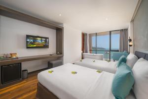 um quarto de hotel com duas camas e uma televisão em The Code Hotel & Spa Da Nang em Da Nang