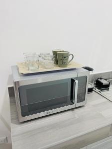 a microwave on a counter with a tray on top at InDomus Rooms in Bacurimi