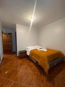 um quarto com uma cama e piso em madeira em VILLA VICTORIA em Chachapoyas