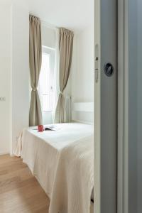 a bedroom with a white bed with a window at Casa Serena - Meryggiare Apartments in Milan