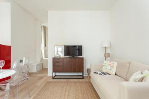 uma sala de estar branca com um sofá branco e uma televisão em Casa Serena - Meryggiare Apartments em Milão