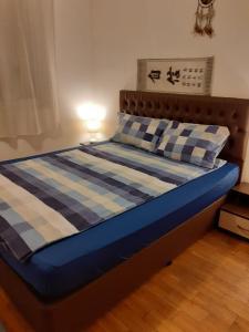 a bed in a bedroom with a blue and white blanket at 2 Rooms Apartment Plovdiv Kichuk Paris in Plovdiv