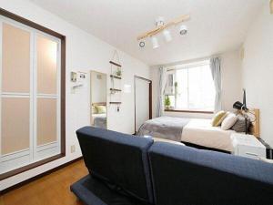 ein Schlafzimmer mit einem Bett und einem großen Fenster in der Unterkunft SouthHouseS札幌市中心部まで徒歩5分 in Sapporo + 6 Fotos
