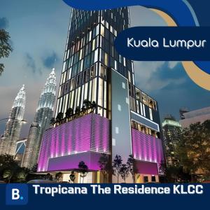 a tall building with purple lighting in front of a city at Tropicana The Residence KLCC in Kuala Lumpur