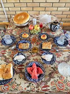 einen Tisch mit blauen und weißen Teller mit Lebensmitteln in der Unterkunft Hotel Mironshox in Buxoro