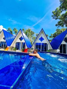 un hombre nadando en una piscina frente a una casa en Voz Resort, en Look