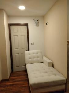 a small room with a white couch and a door at Cabañas Angamos in Punta Arenas
