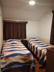 a room with two beds in a room at Cabañas Angamos in Punta Arenas