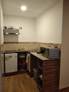 a kitchen with a sink and a microwave at Cabañas Angamos in Punta Arenas +6 photos