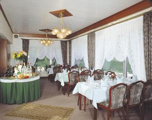 a dining room with white tables and chairs at Hotel Seemöwe in Simmerath