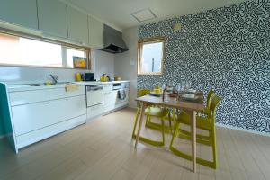 a kitchen with a table and yellow chairs in it at THE LOBS, RUSUTSU in Kimobetsu